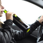Lady drinking wine while driving